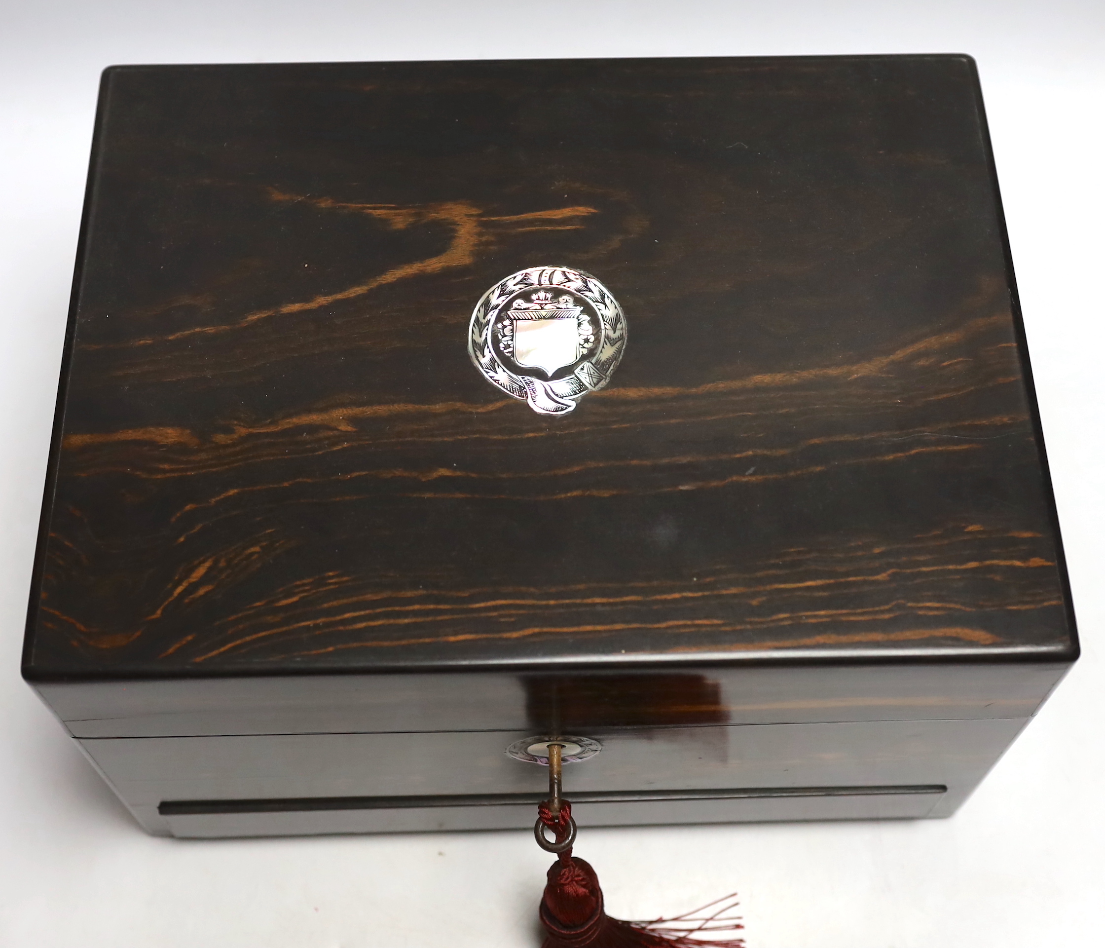 A Victorian coromandel wood toilet box with plated fittings and Mother of Pearl inlay to lid, fitted internal compartments containing glass bottles with plated lids and other accessories, and jewellery drawer underneath